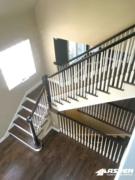 Staircase with a dark handrail and white balusters