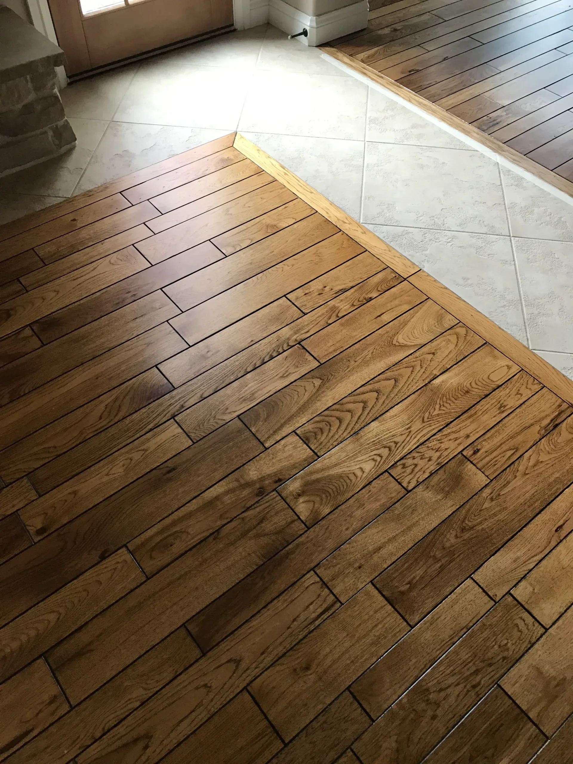 Wood plank floor meeting a tile floor at a clean transition