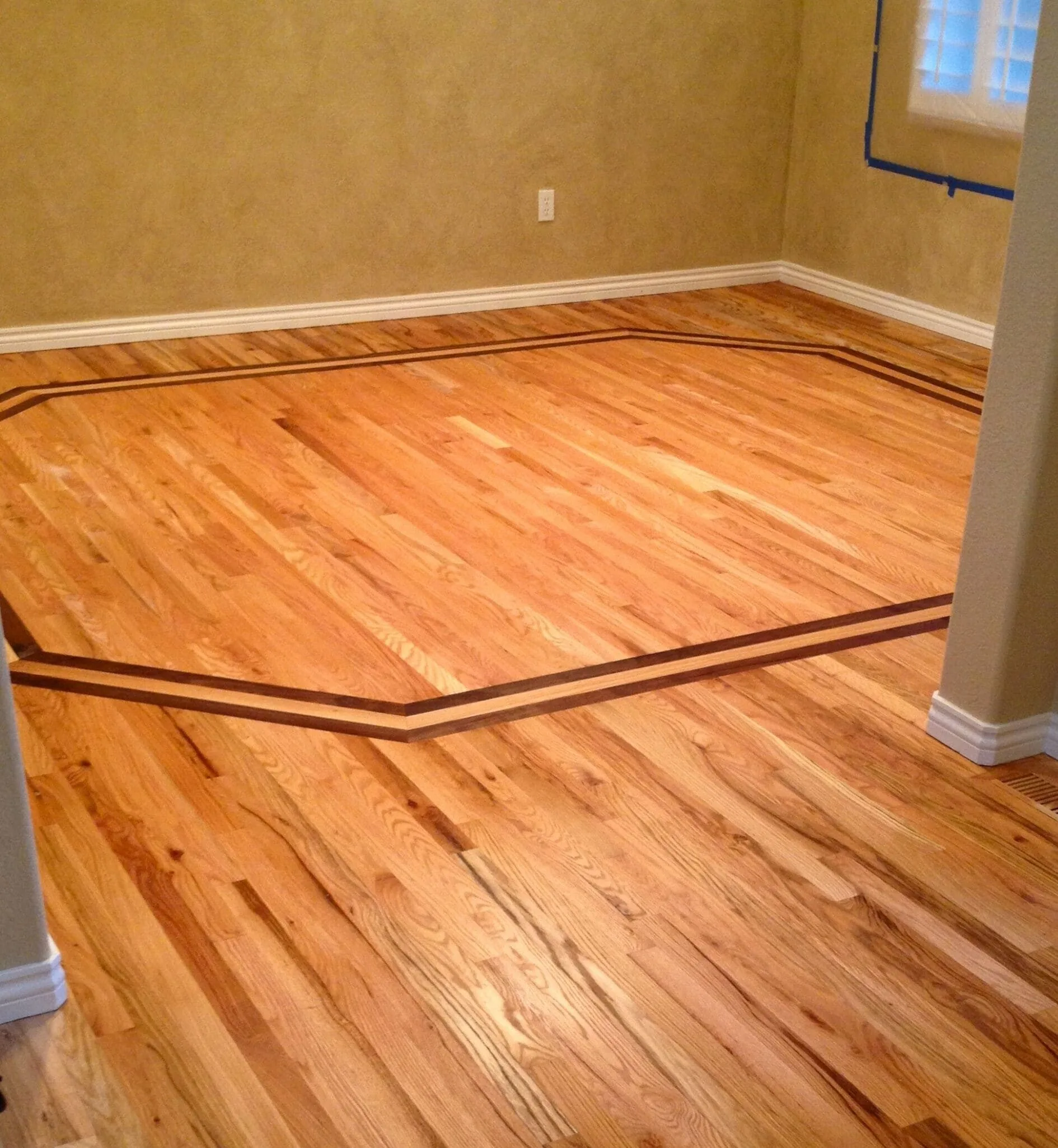 Refinished floor with a contrasting decorative border inlay