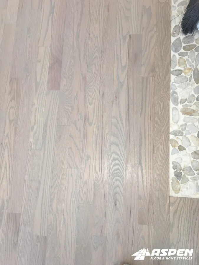 New wood floor meeting a pebble tile border