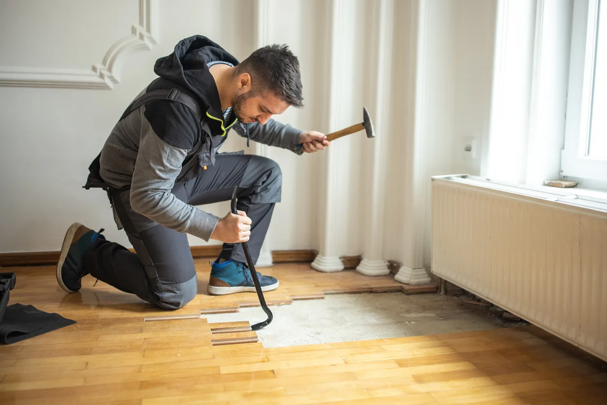 Contractor Removing Damaged Hardwood Panels For Replacement