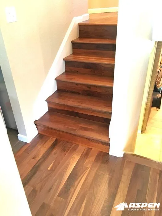 Dark stair treads meeting the hardwood floor below