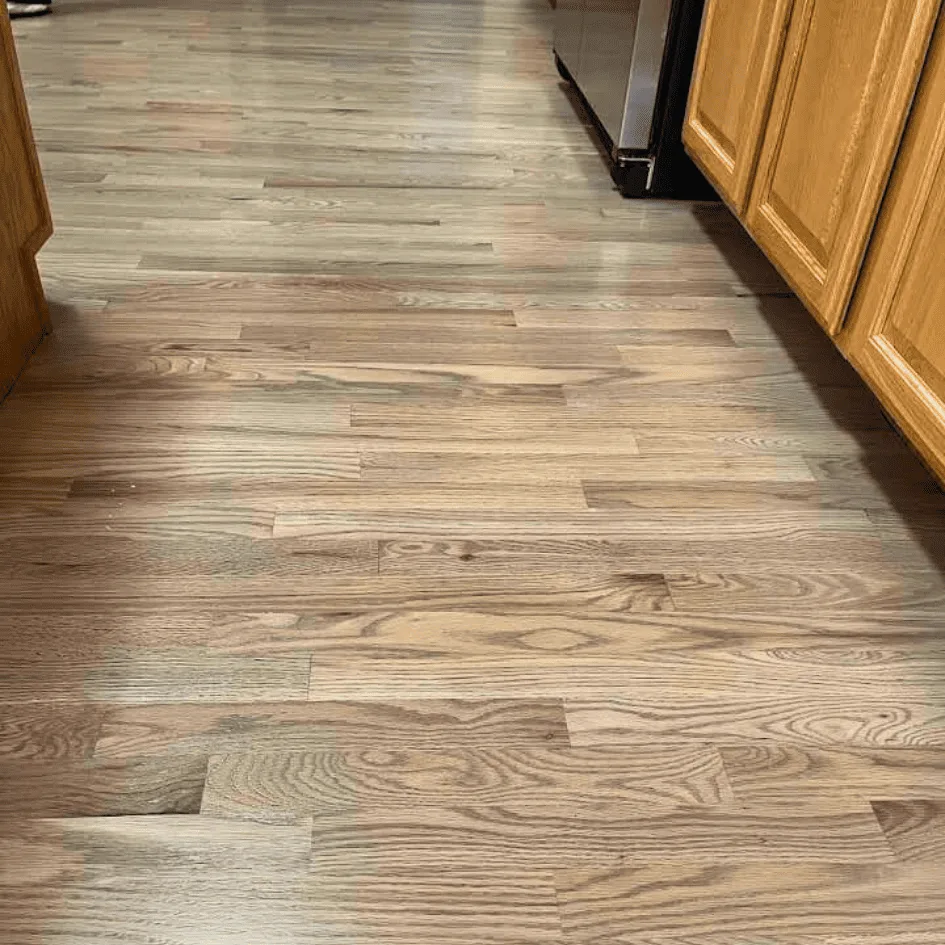 Newly installed oak floor running through a kitchen