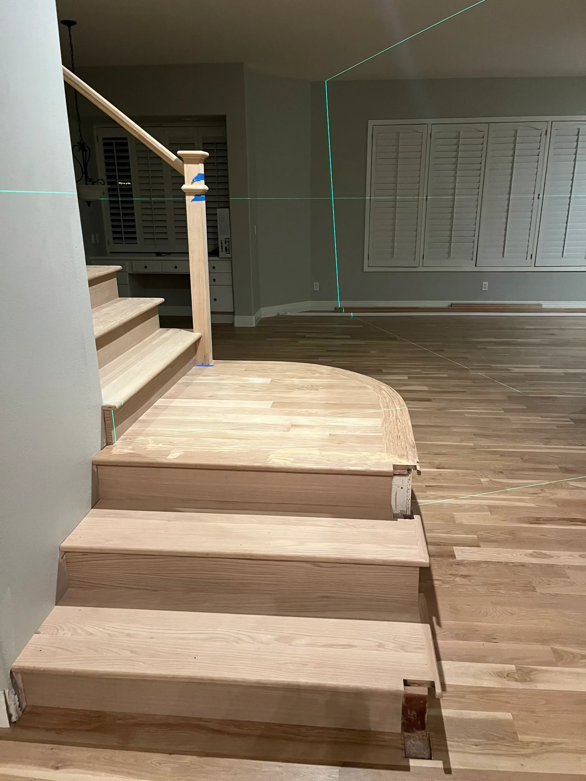Raw wood treads on a curved bottom step, before finishing