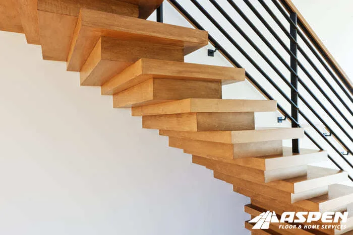 Floating wood staircase with a black metal railing