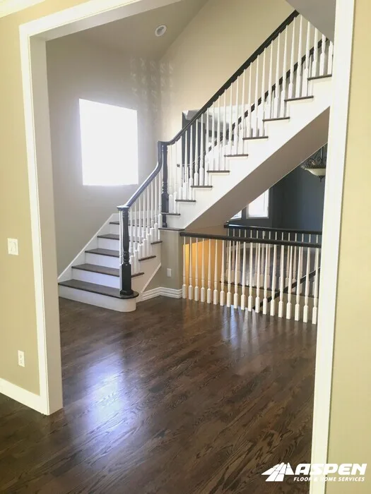 Staircase with white balusters above a hardwood floor
