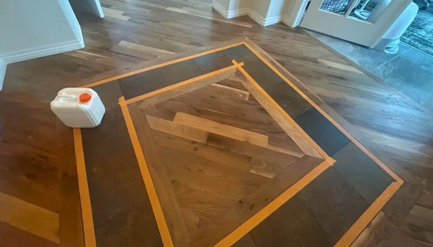 Custom floor inlay masked off with tape before staining
