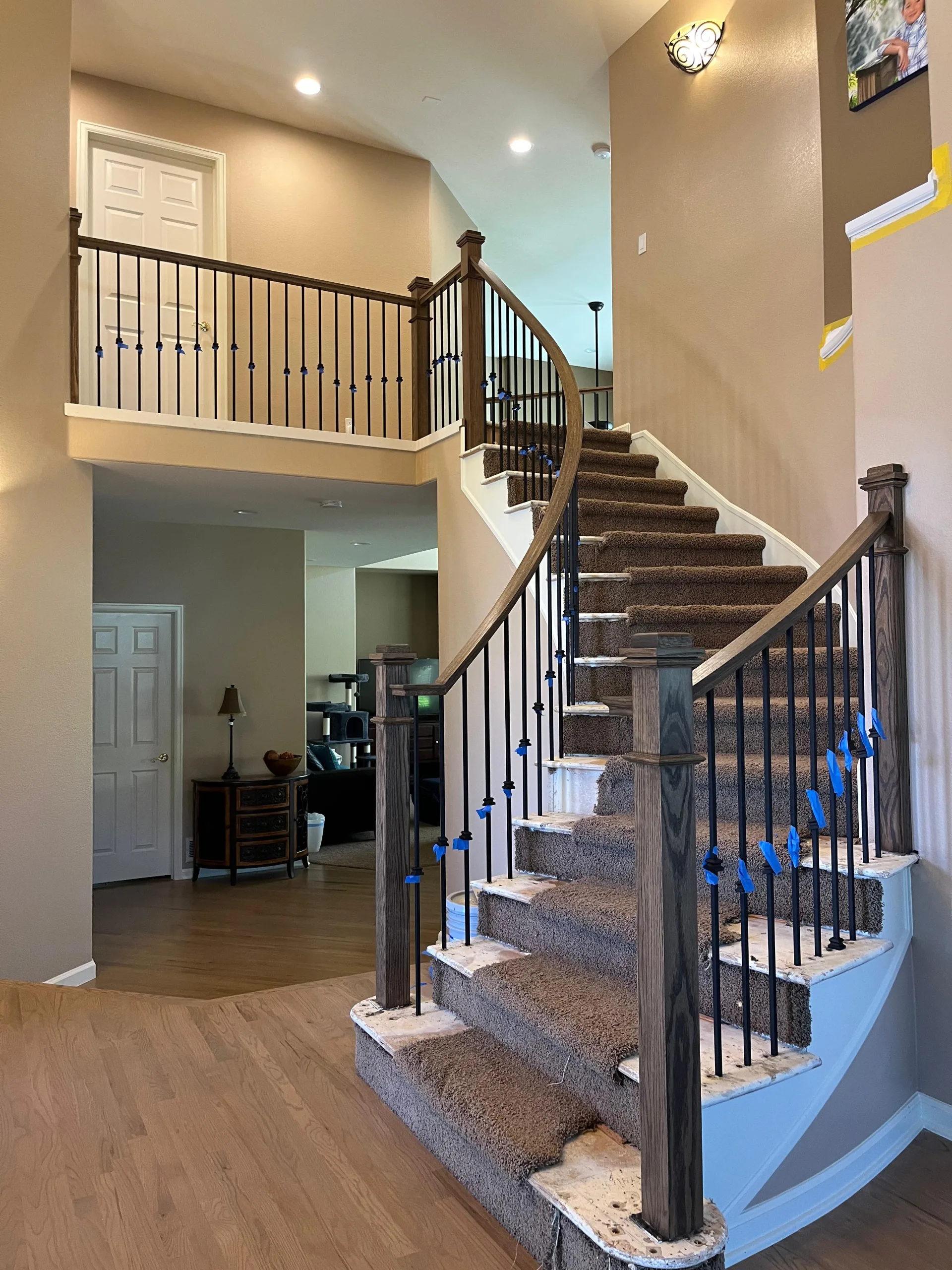 Curved staircase with iron balusters and a wood handrail