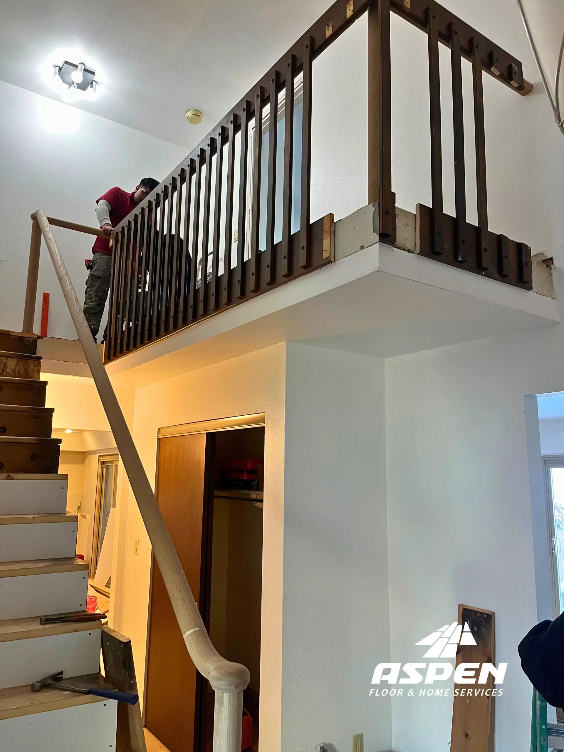 Stair railing with dark balusters being installed