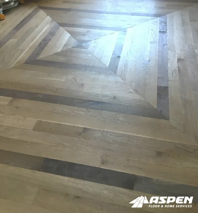 Mixed-tone wood floor where replacement boards blend into the original