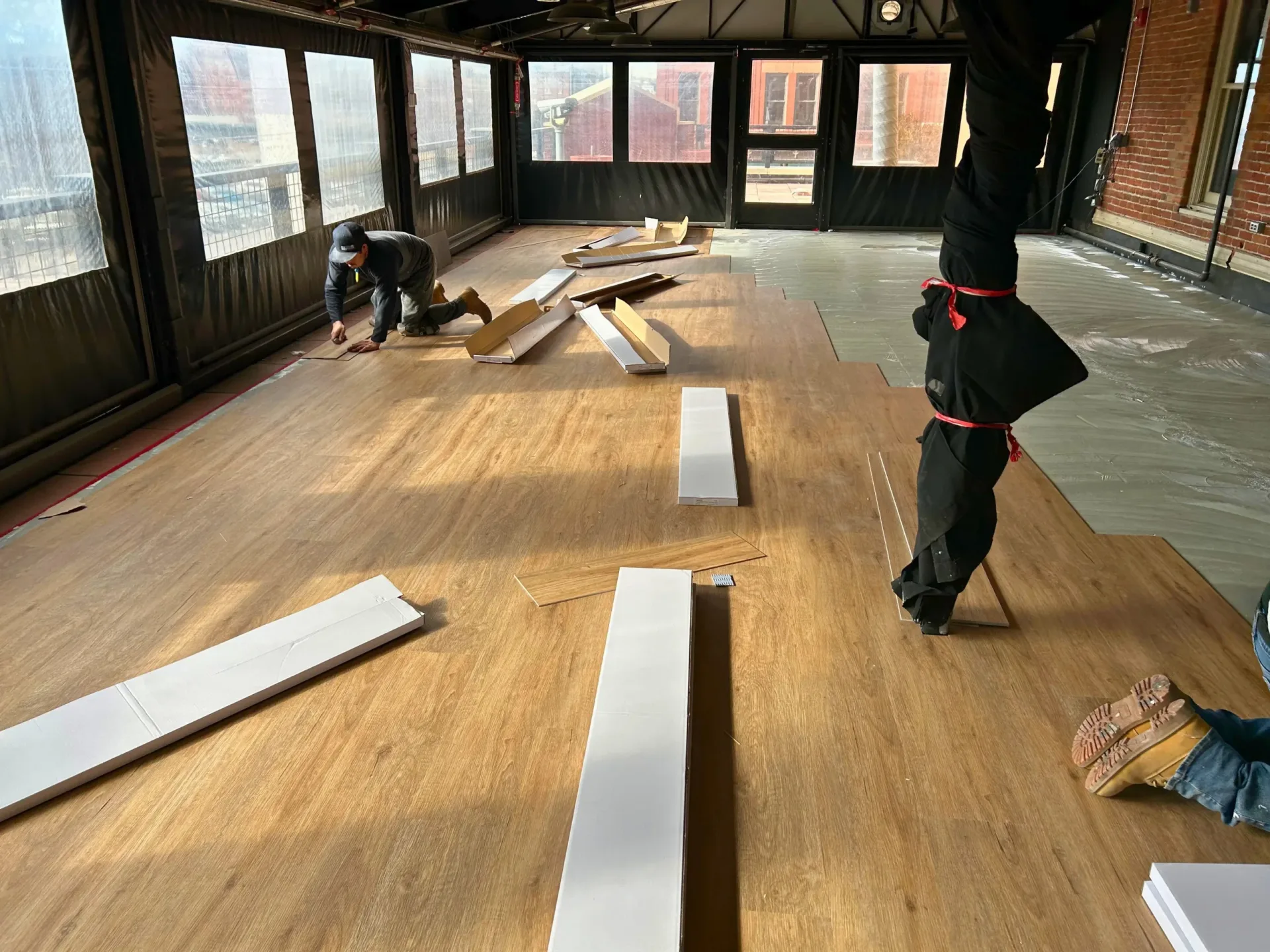 Crew installing wood flooring in a commercial interior