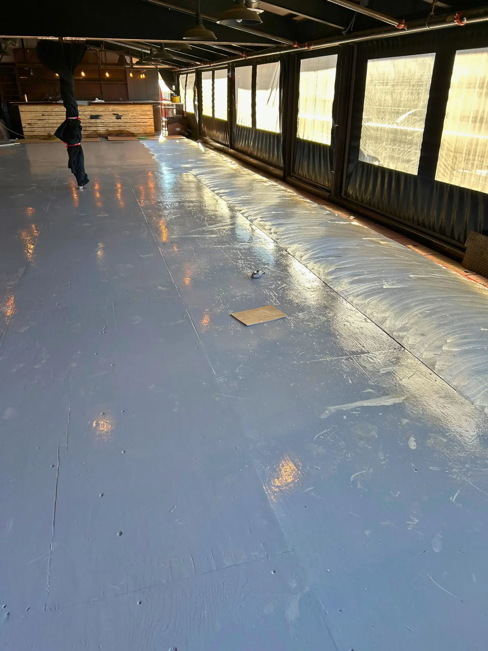 Bare subfloor leveled and checked across a large room before hardwood goes down