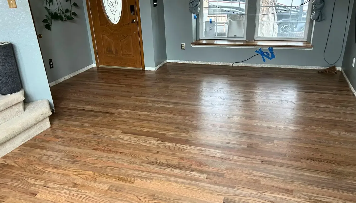 Refinished hardwood in an entry hall with an oval-glass door