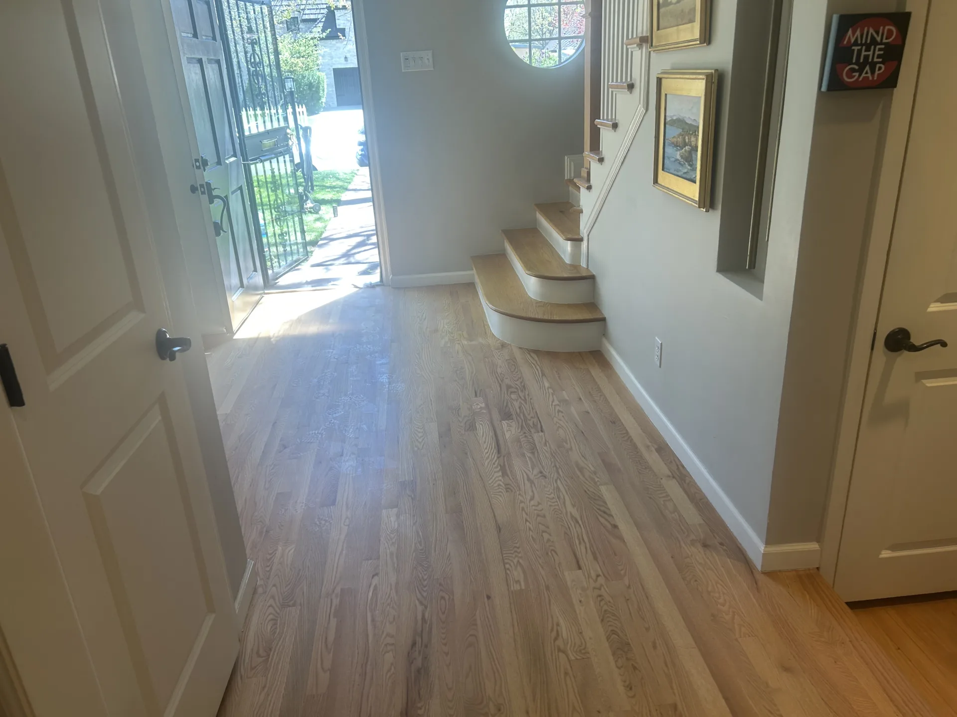 Hardwood floor running down an entry hall toward a glazed front door