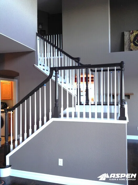 Dark handrail over white balusters on a landing