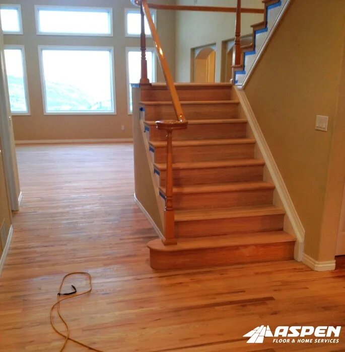 Wood staircase and handrail beside a tall window