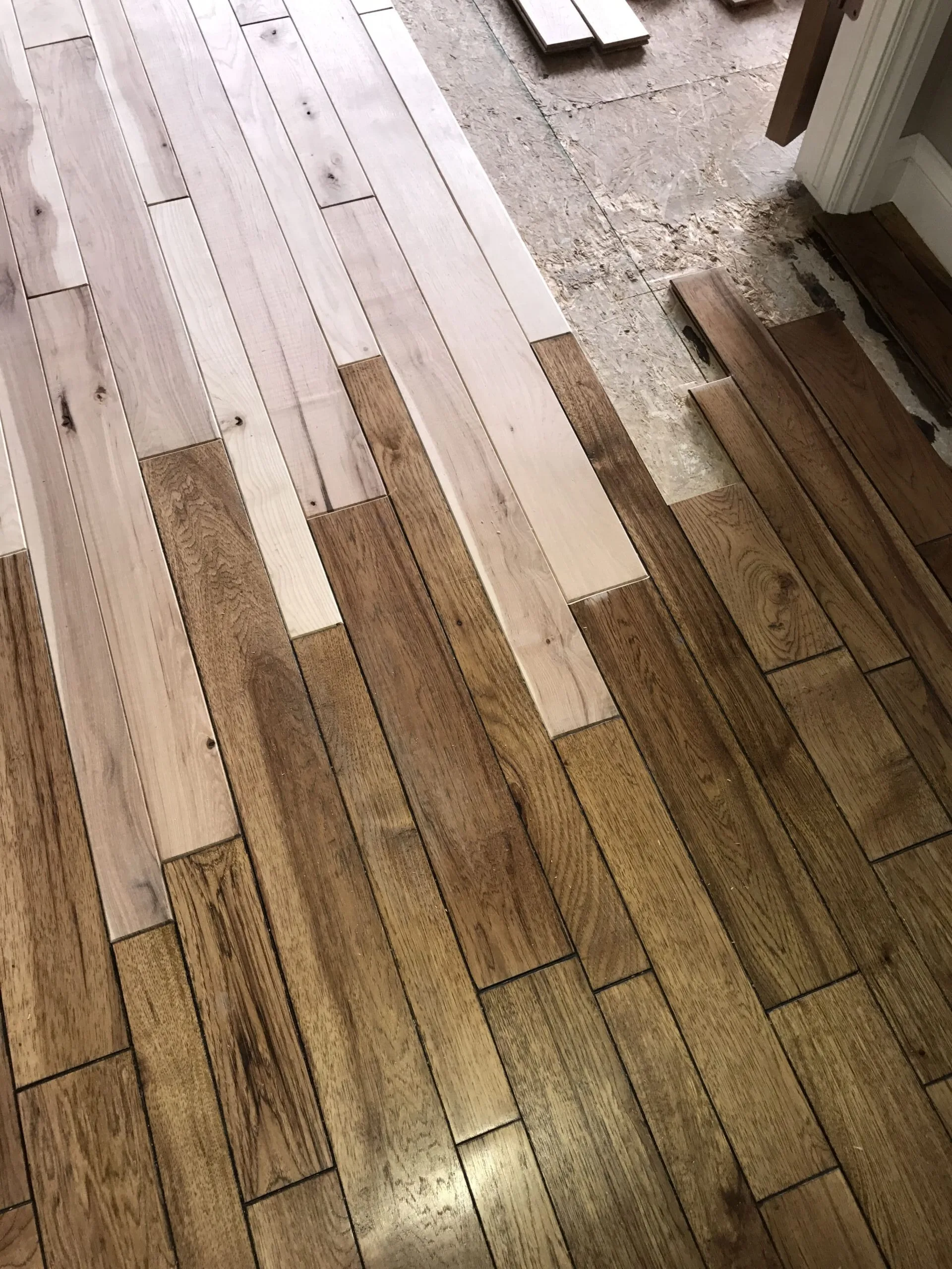 Replacement boards set into an existing hardwood floor before staining