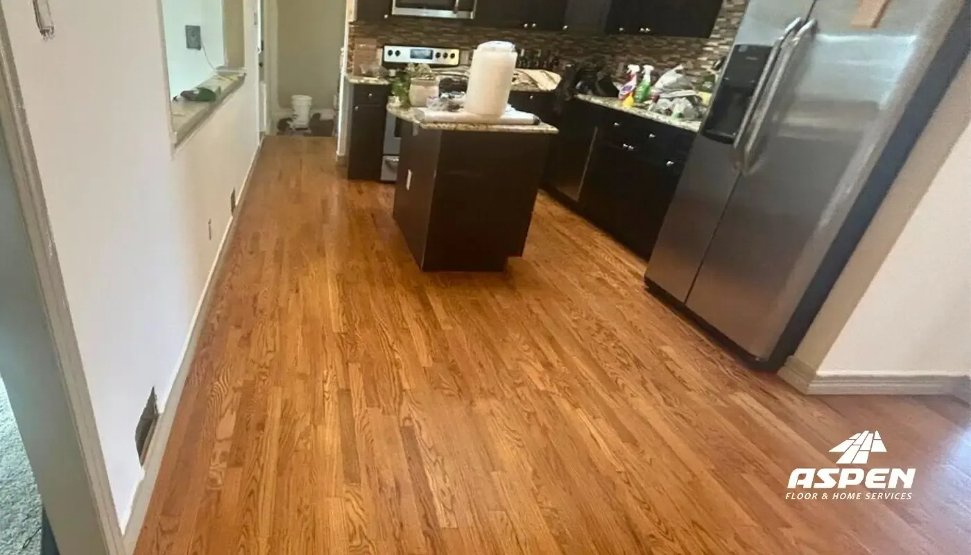 Refinished hardwood running through a kitchen with a central island