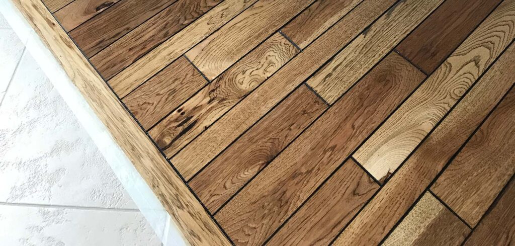 Hardwood flooring close-up showcasing varied wood grain patterns and rich tones, ideal for enhancing Denver home interiors.