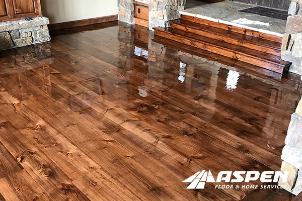 Hardwood floor installation by Aspen Floor & Home Services showcasing polished, rich brown wood flooring in a well-lit interior setting, highlighting quality craftsmanship in Denver, Colorado.