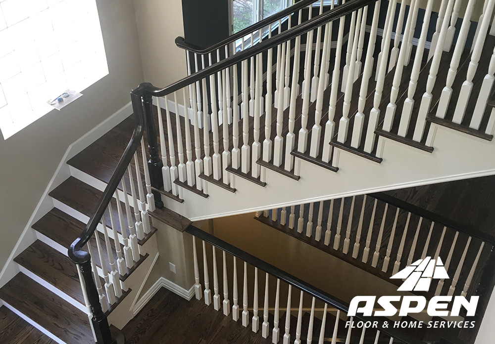 Hardwood staircase with elegant white balusters and dark wood treads, showcasing Aspen Floor & Home Services' craftsmanship in home interior upgrades.