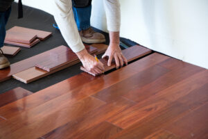 A Contractor installing hardwood floor in a home