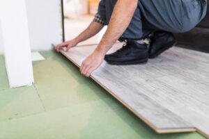 Worker installing hardwood floor with precision and alignment care