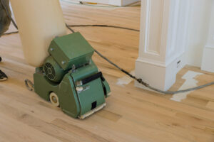 Wood floor sanding contractor using professional equipment for refinishing