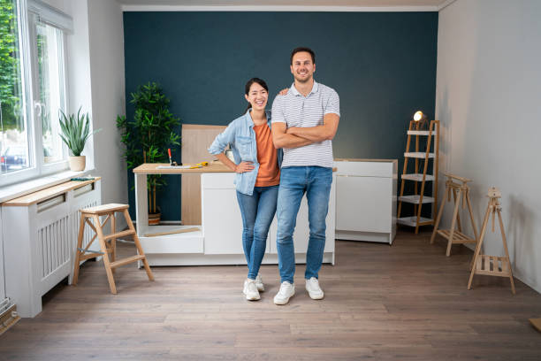 Happy homeowners admiring their beautifully finished hardwood flooring