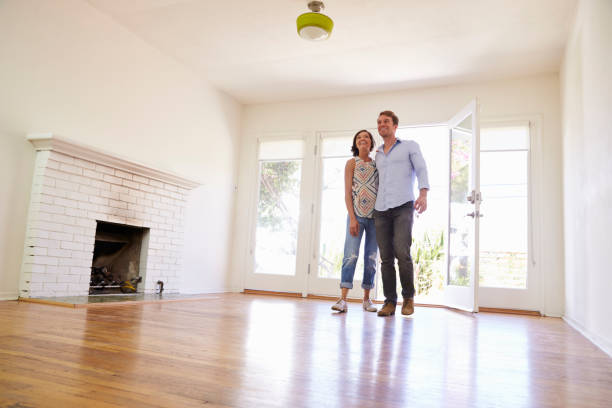 Happy homeowners enjoying the beauty of their newly refinished hardwood floor