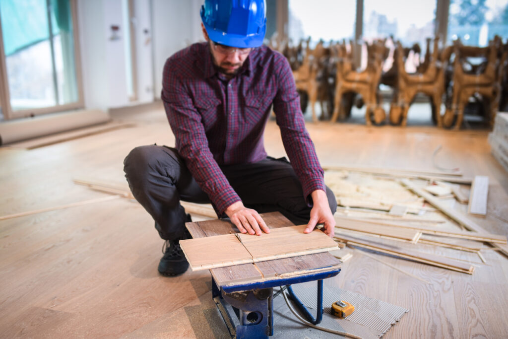 Worker Cutting Hardwood Pieces With Precision On Job Site
