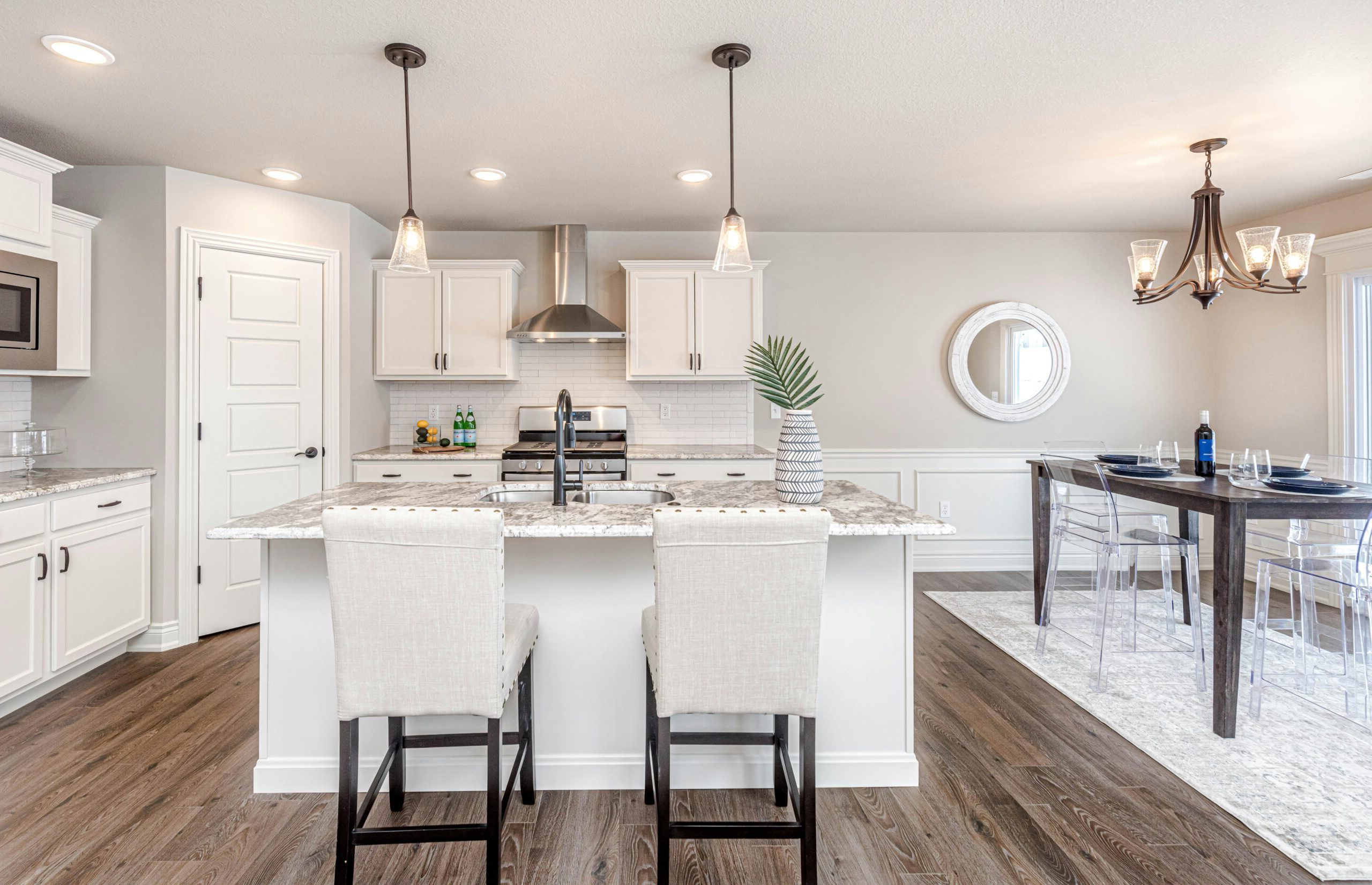 Engineered hardwood flooring installation by Aspen Floor & Home Services in modern open-concept kitchen with white cabinetry and marble countertops in Thornton, Colorado