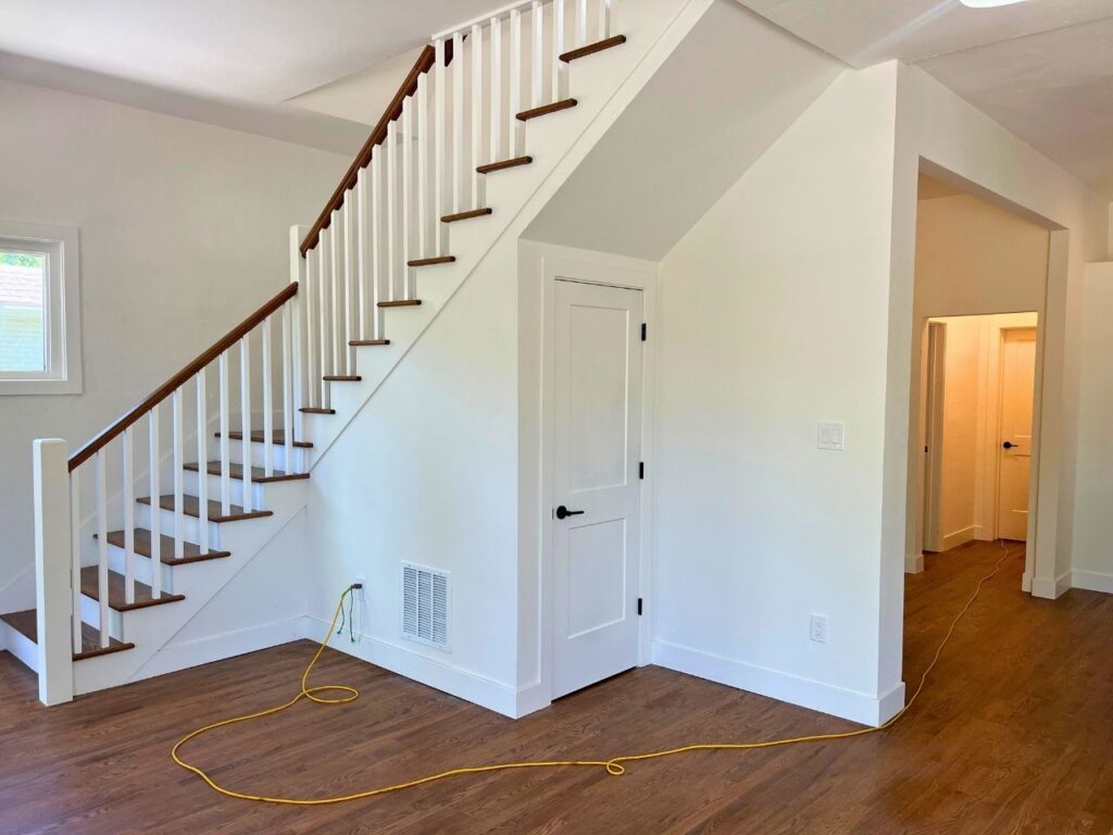 Professional installing exotic acacia engineered hardwood with golden color variations in new construction Thornton home