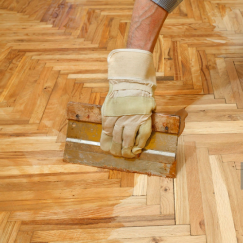 Our specialist applying a coat of stain to the wood floor in Arvada.