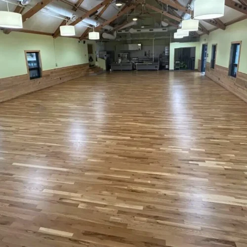 Refinished hardwood flooring in Denver community center hall with stage area