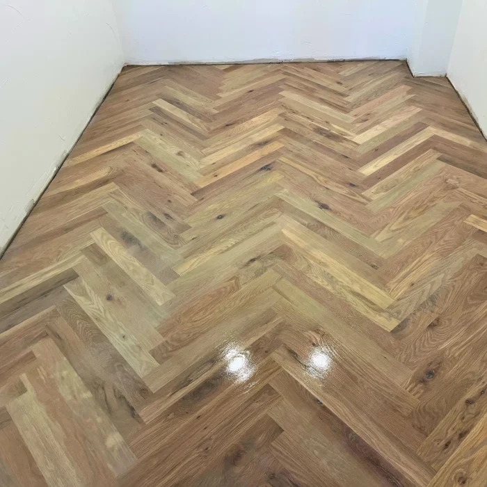 Herringbone pattern hardwood floor installation in progress showing expert craftsmanship by Denver wood flooring contractors
