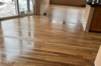 High-gloss hardwood floor refinishing showing mirror-like finish in Denver home dining area