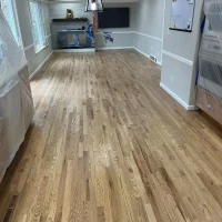 Natural oak hardwood floor installation Denver residential home featuring stone accent feature wall and professional crown molding finish work